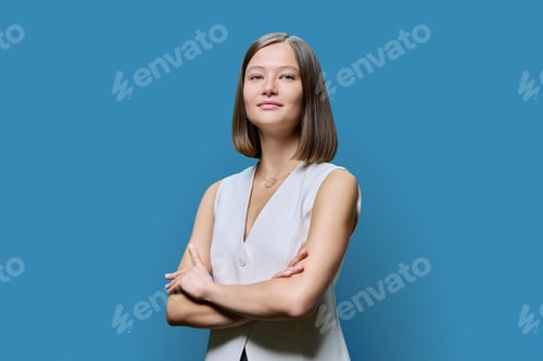 Preview: Portrait of young confident woman on blue studio background