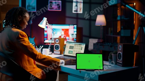 Preview: African american pupil looks at greenscreen display on tablet