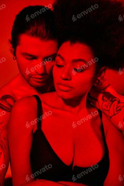 Preview: handsome man with tattoos posing with his african american girlfriend in black bra, sexy couple