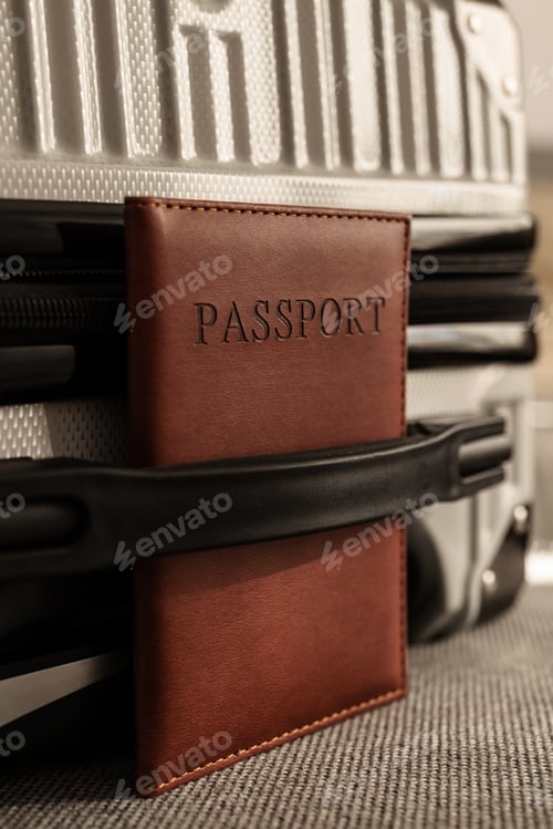 Preview: Closed suitcase with passport, travel documents and luggage ready for departure