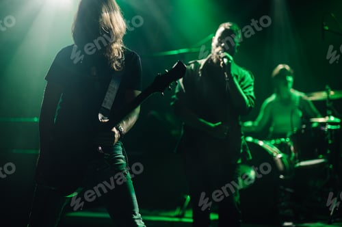 Preview: Rock band performing live on stage with green lighting