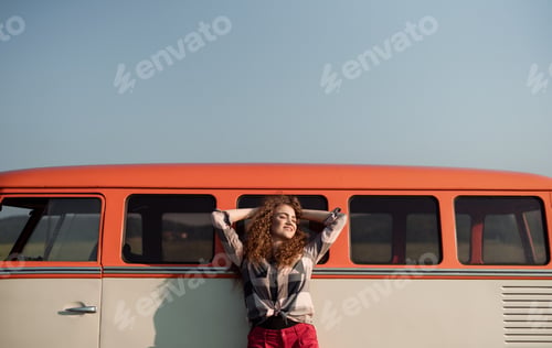Preview: A young girl on a roadtrip through countryside, leaning on a minivan.