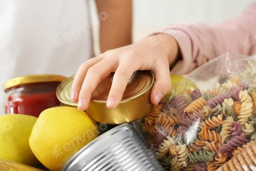 Preview: Girl taking food out of donation box, closeup
