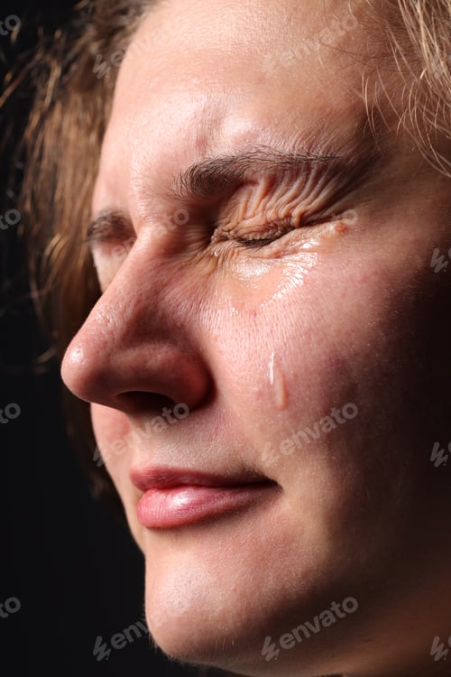 Preview: Sad woman crying on black background, closeup