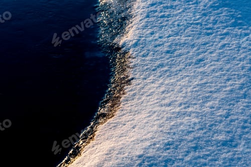 Preview: Frozen ice cold deep lake surface covered with snow close-up sparkling