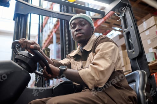 Preview: Worker driving forklift in industrial warehouse