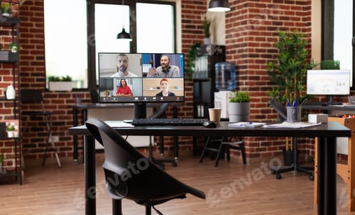 Preview: Monitor with video call conference on table in empty workplace