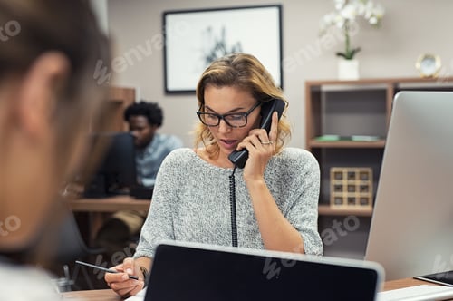 Preview: Businesswoman talking on phone at office