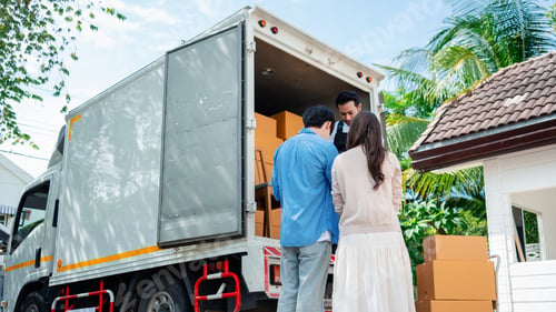 Preview: Asian Couple check while unloading boxes and furniture from a pickup truck
