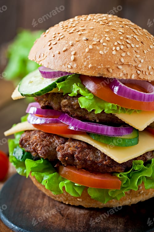 Preview: Big juicy hamburger with vegetables and beef on a wooden background in rustic style