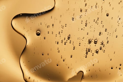 Preview: The beautiful texture of the cosmetic serum on a gold background that takes up most of the photo.
