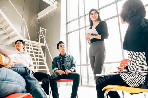 Preview: Coworkers discussing in meeting room at the office