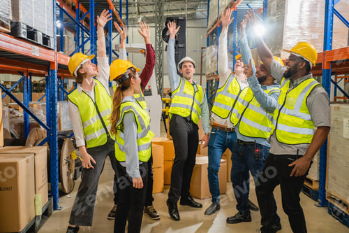 Preview: Group of happy warehouse workers celebrating success in warehouse