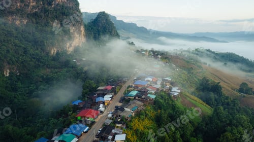 Preview: Traditional local village of Ban Jabo with foggy and road passing through community in the morning
