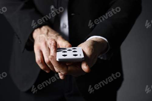 Preview: Illusionist with playing cards on grey background, closeup