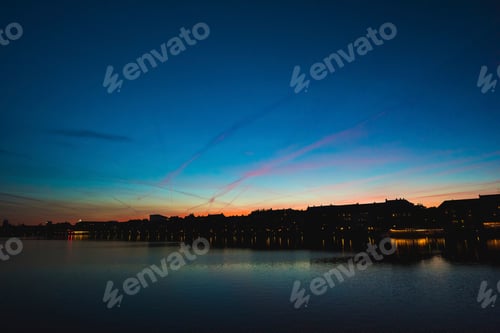 Preview: Sunset behind a silhouette of a town by the water