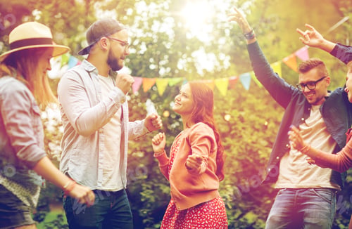 Preview: happy friends dancing at summer party in garden