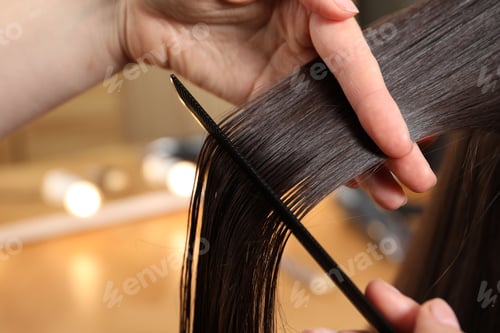 Preview: Hairdresser combing client's hair in salon, closeup