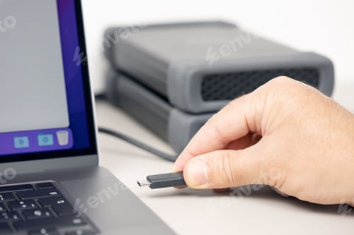 Preview: Hand connecting a External hard disk to a modern laptop computer