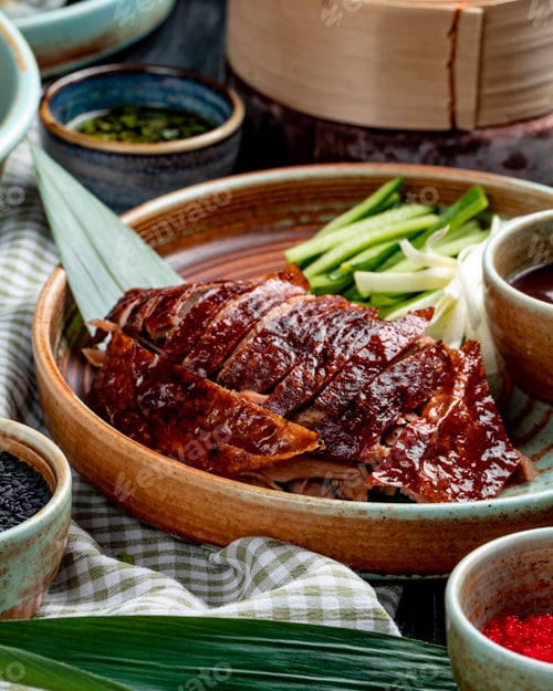 Preview: side view of traditional asian food peking duck with cucumbers and sauce on a plate