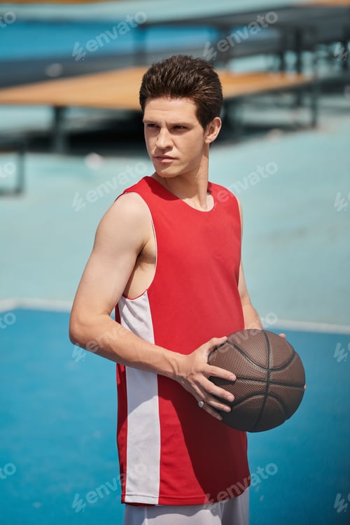 Preview: Dribbling dreams: young man with basketball on court
