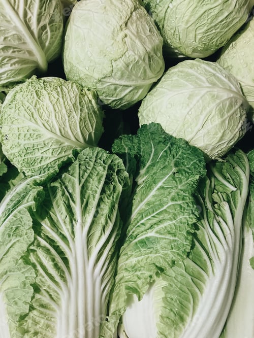 Preview: Beautiful green cabbage heads stacked neatly in a grocery store