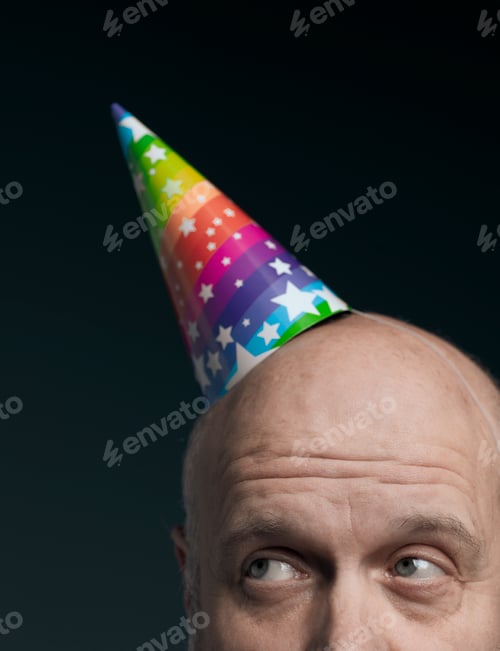 Preview: Funny senior bald man with party hat