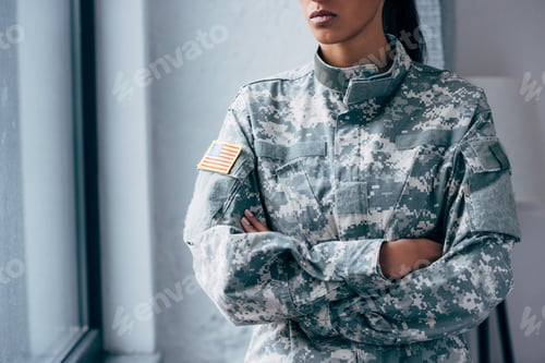 Preview: cropped view of african american female soldier in military uniform with usa flag emblem