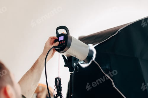Preview: young man preparing the device for photo session