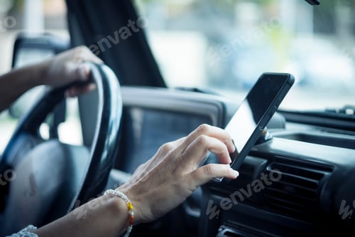Preview: Close up of woman hand setting the gps online navigator on the phone while drive