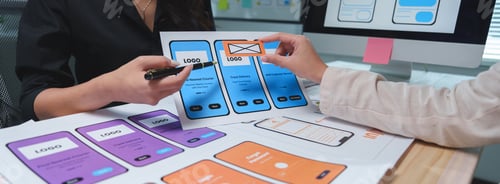 Preview: Two ux ui designers are working together, discussing wireframes and prototypes of mobile application