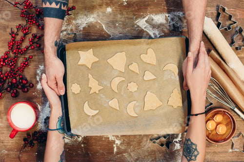 Preview: cropped shot of couple holding tray with delicious christmas cookies