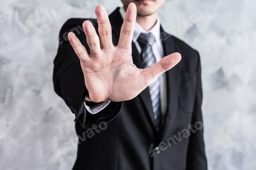 Preview: Close up of businessman showing palm handsign on grunge background.