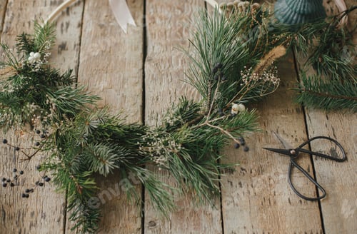 Preview: Modern christmas wreath with spruce branches, herbs, scissors, candle on rustic wood.Merry Christmas