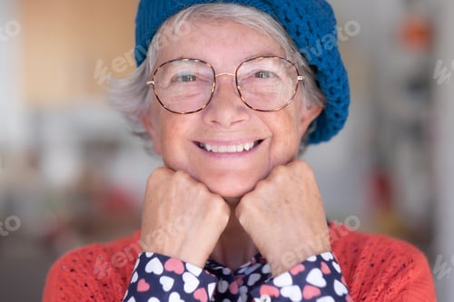 Preview: Close up portrait of beautiful senior woman smiling wearing eyeglasses and blue cap