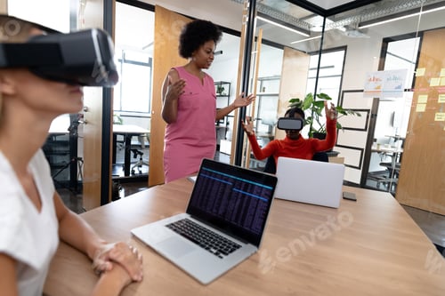 Preview: Diverse group of business colleagues using vr headset in meeting room