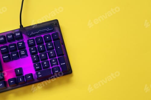 Preview: Modern RGB keyboard on yellow background, top view. Space for text