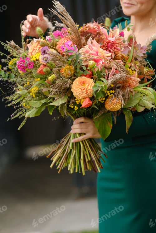 Preview: A large bouquet of mixed flowers in the hands of a woman. The work of a florist in a flower shop