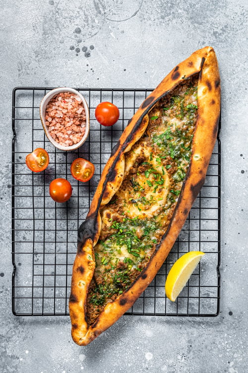 Preview: Turkish pide, traditional pie with beef meat and vegetables. White background. Top view