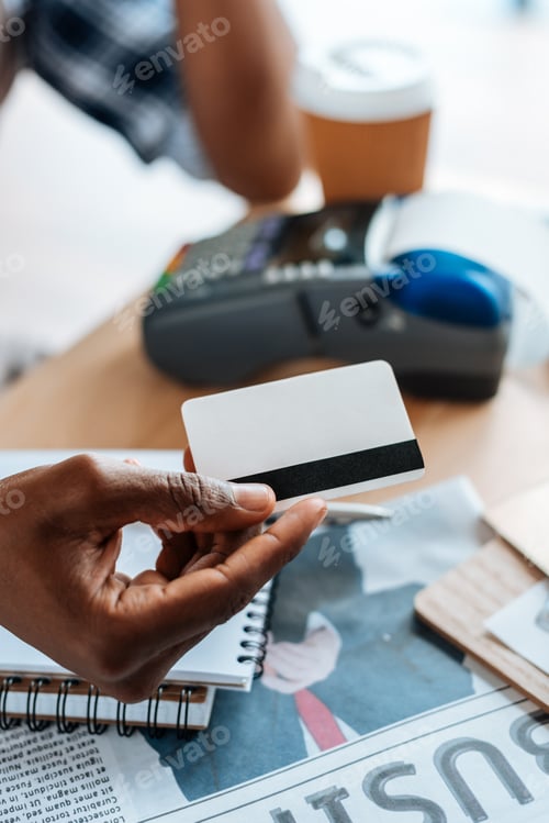 Preview: cropped view of african american man working with credit card and terminal in coffee shop
