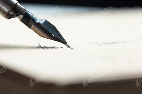 Preview: Close focus on a fountain pen writing on cream colored paper in natural light