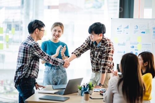 Preview: Glad to work with you! Fashionable young man in smart casual wear holding hands and smiling while wo