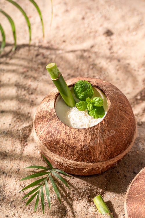 Preview: Delicious pinacolada in coconut served with a bamboo straw.