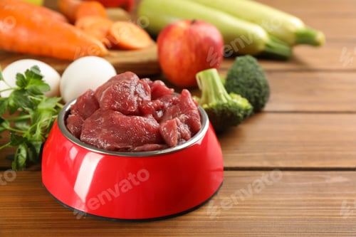 Preview: Raw meat and fresh ingredients on wooden table, closeup. Natural pet food
