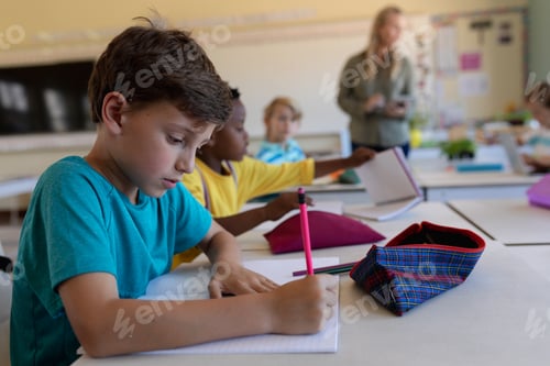 Preview: Schoolboy sitting at a desk in an elementary school classroom