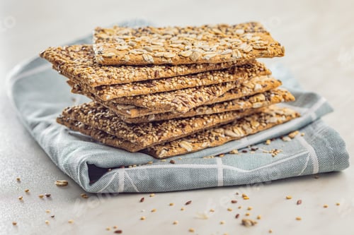 Preview: Knackebrot with sesame seeds. Wholegrain crispbread on napkin on kitchen table.