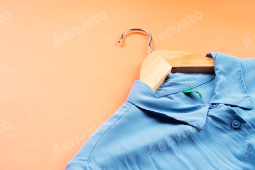 Preview: Blue Collared Shirt on Hanger with Peach Backdrop