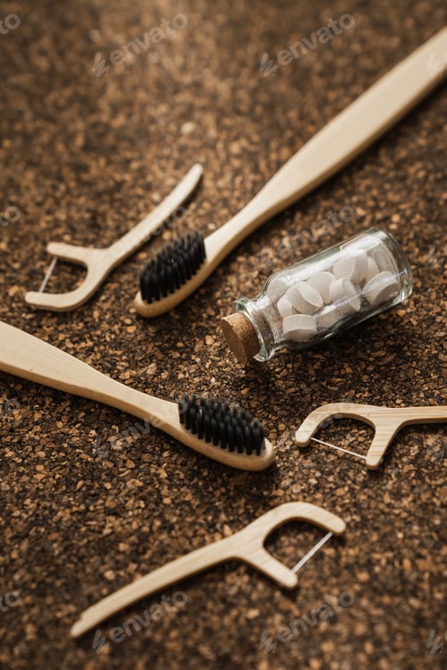 Preview: Bamboo Toothbrushes, Floss Picks and Toothpaste Tablets on Cork Surface