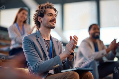 Preview: Happy entrepreneur applauding after successful business seminar in conference hall.