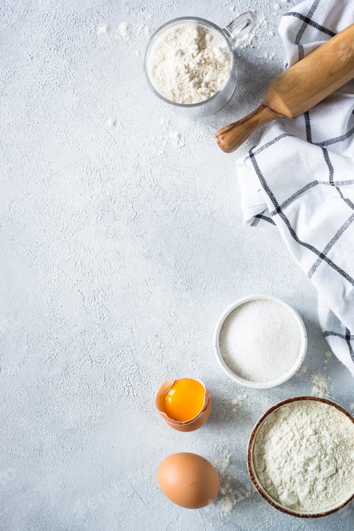 Preview: Baking background ingredients. Flour, sugar, eggs and rolling pin at light stone table.